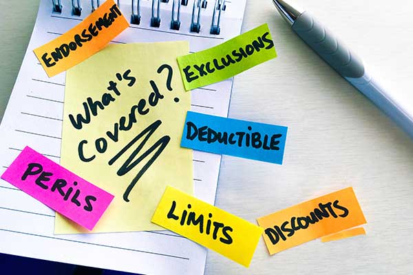 Sticky notes on a notepad asking insurance claim questions